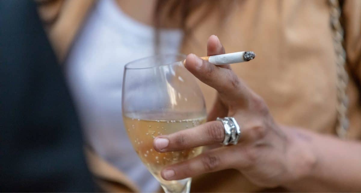 Woman holding a glass of alcohol and a cigarette