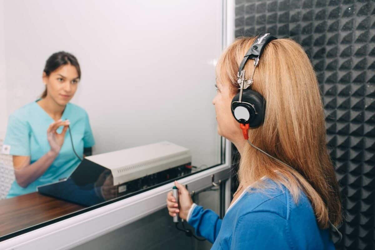 Audiologist giving patient hearing test